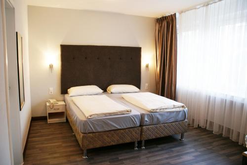 杜塞尔多夫地铁酒店的一间卧室设有一张床和一个大窗户