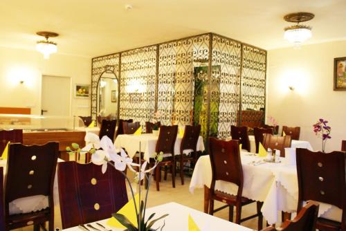 杜塞尔多夫地铁酒店的餐厅配有白色的桌椅和镜子