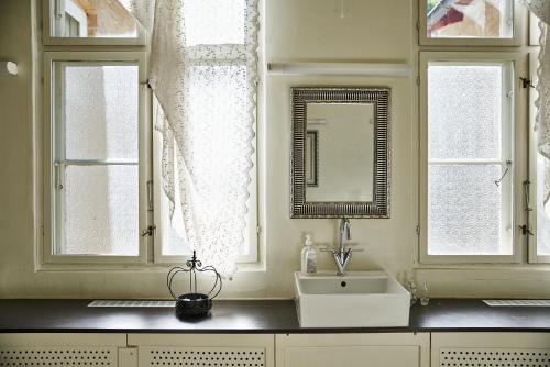 奥胡斯奥胡斯单旅馆的一间带水槽的浴室和两个窗户