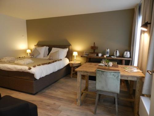 达默B&B De Swaenhoeck的酒店客房配有一张床铺和一张桌子。