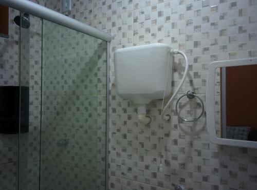 贝伦Hotel Toraryca的浴室设有淋浴间和白色的储物箱
