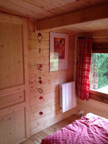BréchaumontChalet Clarimaud的小木屋卧室设有床和窗户