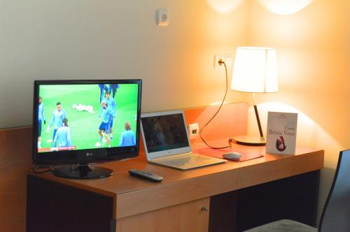 莱昂FC莱昂公主酒店的一张带笔记本电脑的桌子和一台电视机