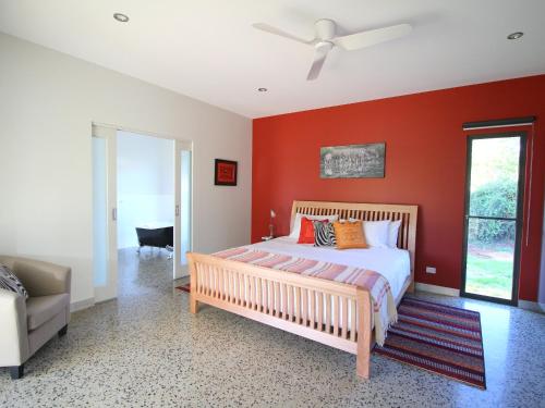 布赖特贝尔斯阿尔卑斯3号度假屋的一间卧室设有红色的墙壁、一张床和一张沙发