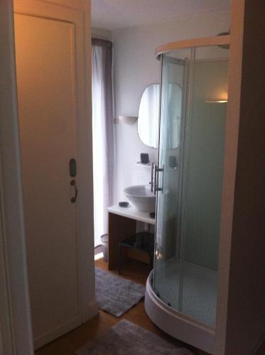布鲁塞尔18号酒店的一间带玻璃淋浴和水槽的浴室