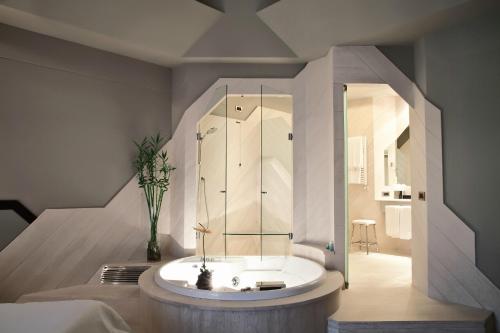 罗马伊萨酒店的设有带浴缸和淋浴的浴室。