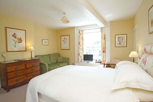 MereB&B Castleton House的卧室配有一张白色的大床和一张沙发。