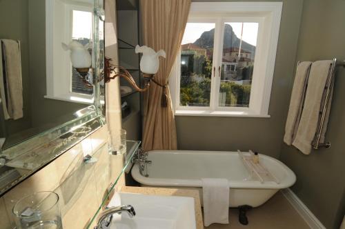 开普敦修道院庄园豪华宾馆的带浴缸、水槽和窗户的浴室