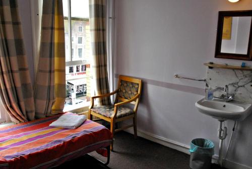 阿姆斯特丹塔玛拉酒店的客房设有椅子、水槽和窗户。