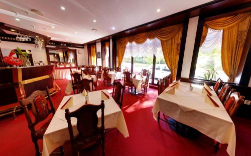 卡罗维发利圣彼得堡酒店的餐厅设有2张桌子和椅子以及窗户。