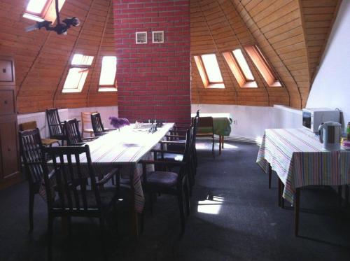 凯奇凯梅特Park Vendégház的用餐室设有桌椅和窗户。