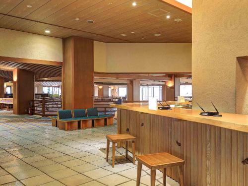 会津若松Ookawaso的大堂设有1间带长凳和桌子的酒吧