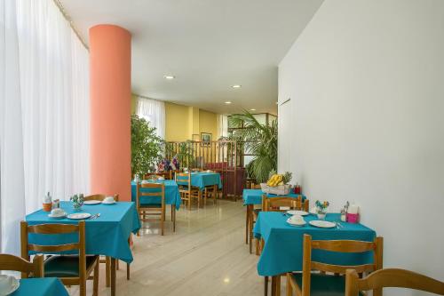 雅典涅斐勒酒店的一间配备有蓝色桌椅的用餐室