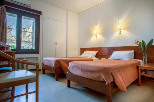 雅典涅斐勒酒店的一间卧室设有两张床和窗户。