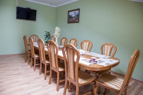 利沃夫Lions Heart Hostel的一间带木桌和椅子的用餐室