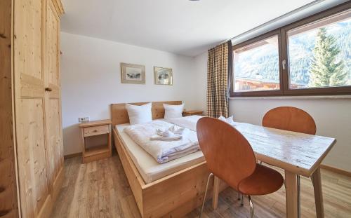 萨尔巴赫Appartement Kohlmais的一间卧室配有一张床、一张桌子和一个窗户。