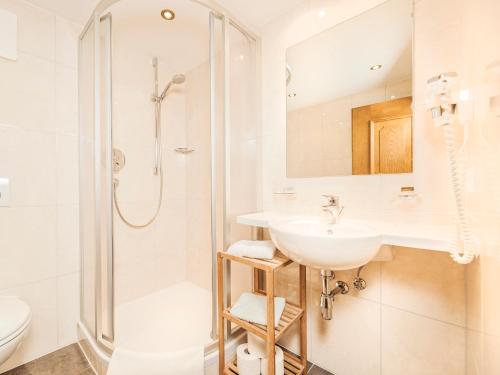 盖洛斯Farm Resort Geislerhof的白色的浴室设有水槽和淋浴。