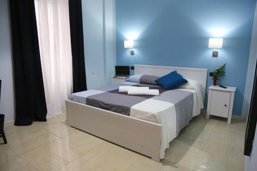 玛格丽塔萨沃亚Napolitano Palace的一间卧室配有一张蓝色墙壁的床