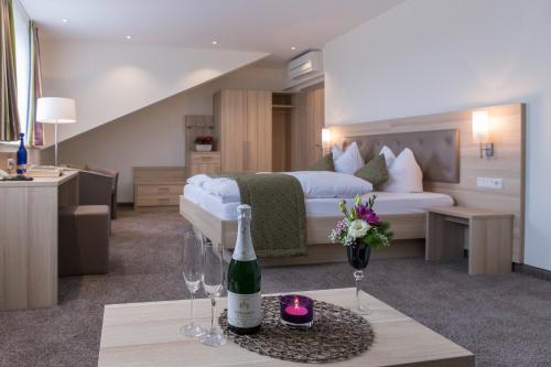 巴特索登-萨尔明斯特比肯霍夫餐厅酒店的酒店客房,配有一张床和一瓶葡萄酒