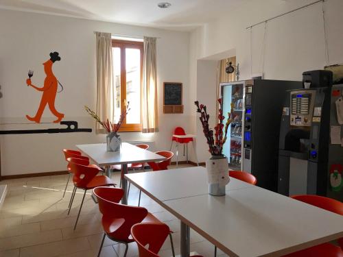 克雷莫纳阿切托酒店的厨房配有白色的桌子和红色的椅子