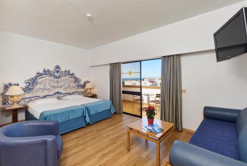 阿尔布费拉布里萨索尔公寓式酒店的酒店客房配有床、沙发和电视。