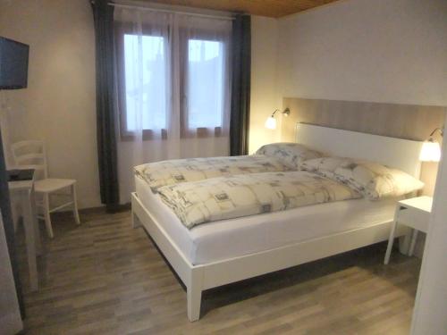Ritzingen巍斯峰酒店的卧室配有一张大白色床和窗户