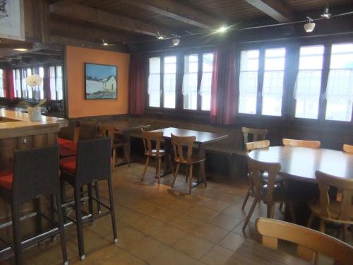 Ritzingen巍斯峰酒店的用餐室设有桌椅和窗户。