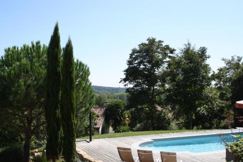 VillarsLa Verte Dordogne的花园内的游泳池,花园内有椅子和树木