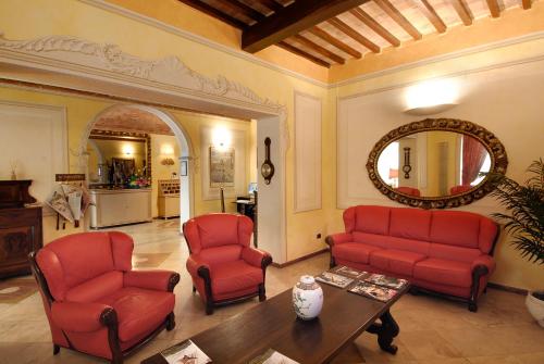 比萨波罗格纳酒店的客厅配有红色的椅子、桌子和镜子