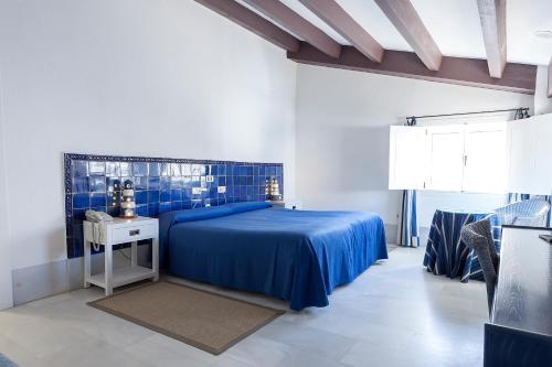 圣何塞帕奇卡夫人酒店的一间卧室配有一张蓝色的床和一张桌子