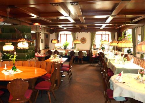 绍普夫海姆Historisches Genusshotel Löwen的一间在房间内配有桌椅的餐厅