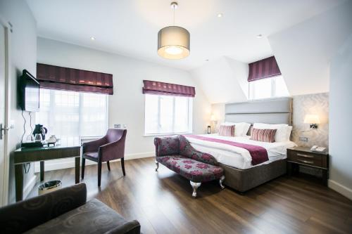 伦敦支柱酒店的酒店客房配有一张床、一张桌子和一把椅子。