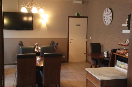 克科文隆梅尔布鲁克酒店的一间带桌椅和电视的用餐室