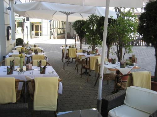 巴特索登-阿伦多夫维拉塔尔酒店的一排桌子,上面摆放着黄色的椅子和雨伞