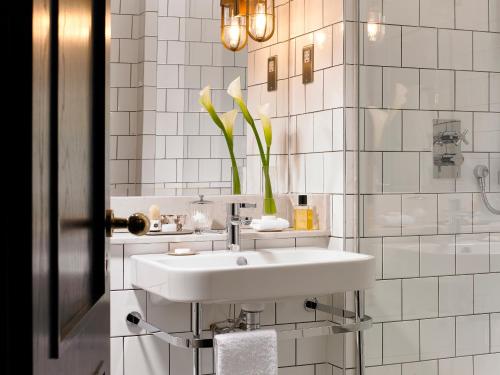都柏林圣殿酒吧酒店的白色的浴室设有水槽和花瓶
