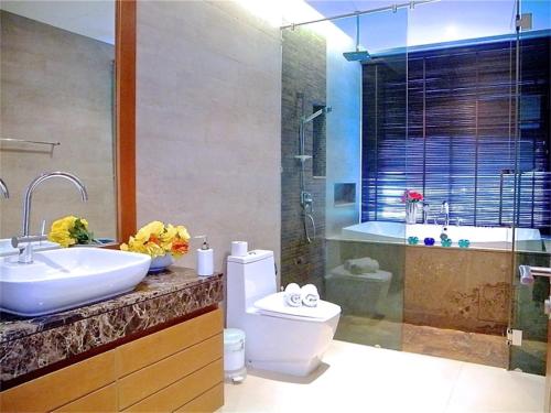 拉威海滩伊娃拉威三卧室私人泳池别墅的浴室配有盥洗盆、卫生间和浴缸。