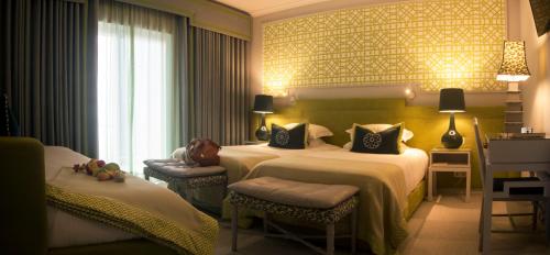 法蒂玛Coração de Fatima Boutique Hotel的酒店客房设有两张床和窗户。