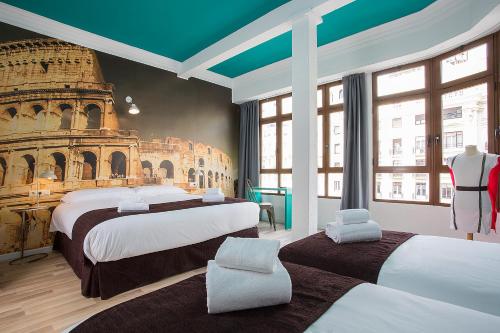 瓦伦西亚Casual Vintage Valencia的酒店客房设有两张床和一张罗马斗兽场壁画