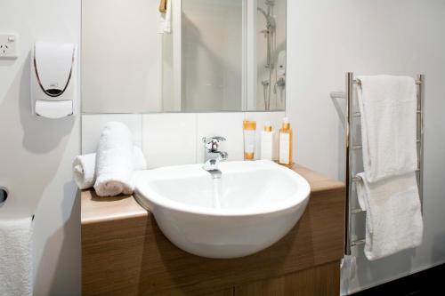奥克兰Nesuto St Martins Apartment Hotel的浴室设有白色水槽和镜子