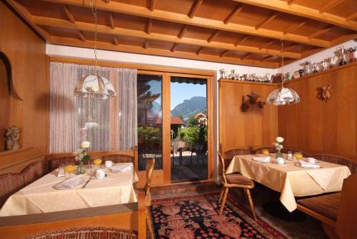 齐勒河谷采尔加尼马克西米利安酒店的一间设有两张桌子和窗户的用餐室