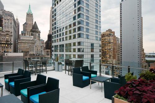 纽约Club Quarters Hotel World Trade Center, New York的大楼内带桌椅的屋顶露台