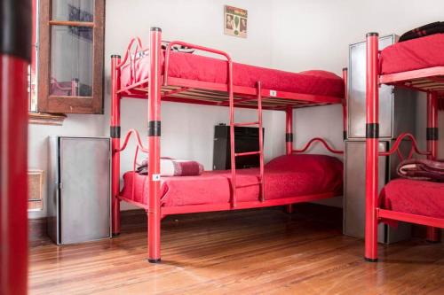 布宜诺斯艾利斯Play Hostel Soho的红色家具的客房内设有两张双层床。