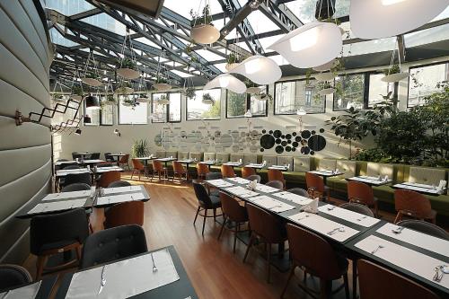 布加勒斯特贝特洛酒店的用餐室设有桌椅和窗户。