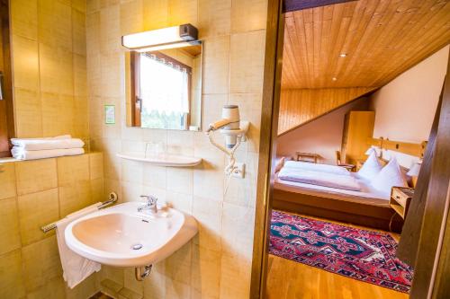 卡特恩伯恩瓦德酒店的一间带水槽的浴室和一张位于客房内的床
