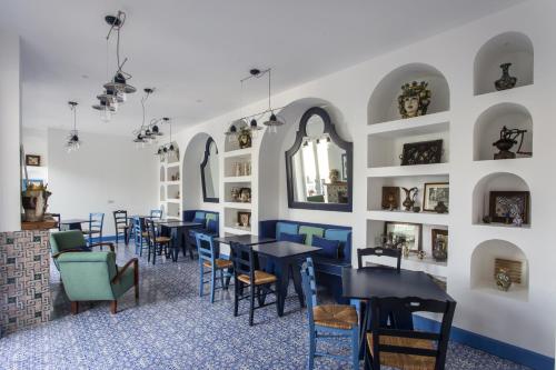 索伦托米格农陈列酒店的用餐室配有桌椅和带镜子的墙壁