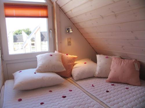 奥斯特赫鲁普卡特加特露营地的配有枕头和窗户的客房内的一张床位