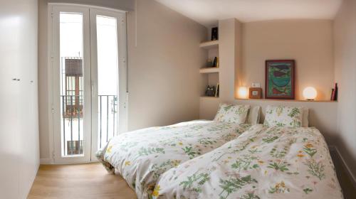 科尔多瓦河上公寓的一间卧室配有一张带花卉棉被的床