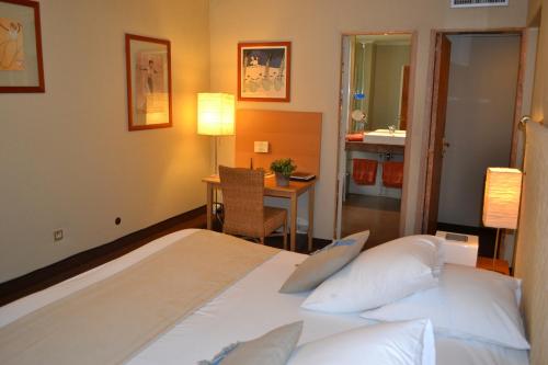 马赛圣弗雷奥尔酒店的配有一张床、一张桌子和一张桌子的酒店客房