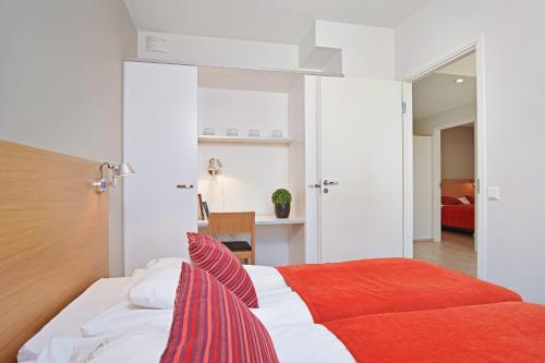 坦佩雷Forenom Serviced Apartments Tampere Pyynikki的一间卧室配有一张带红色毯子的床