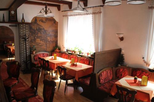 鲁多尔施塔特Hotel Thüringer Hof的餐厅设有桌椅和窗户。